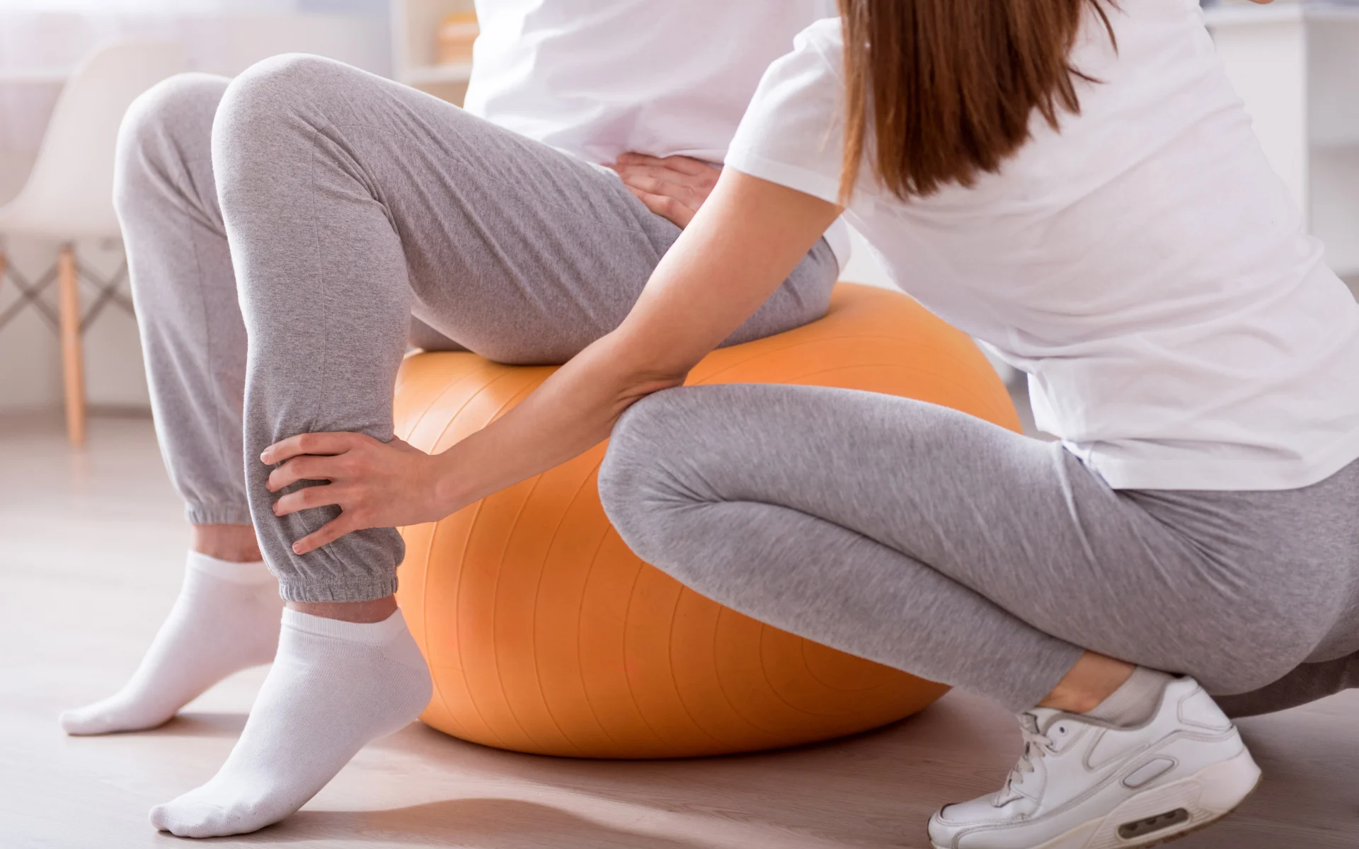 Fisioterapeuta mobilizando o membro de uma paciente na maca